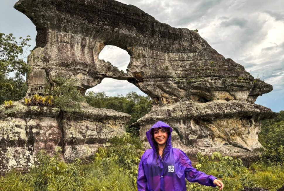 Woman standing in front of the Gate of Orion, a mystical rock formation in Guaviare, Colombia