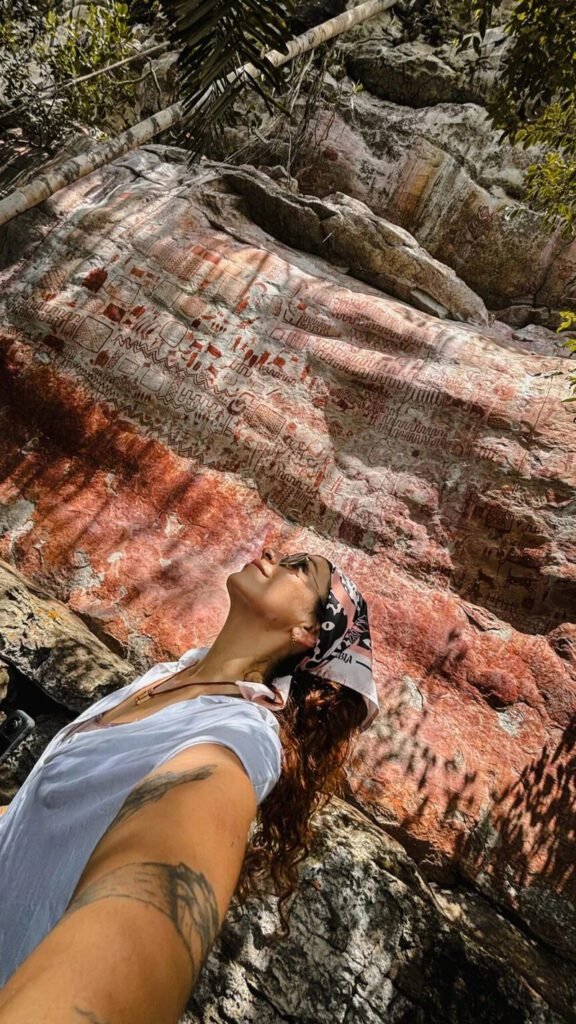 Traveler observing ancient rock art walls in the Colombian Amazon