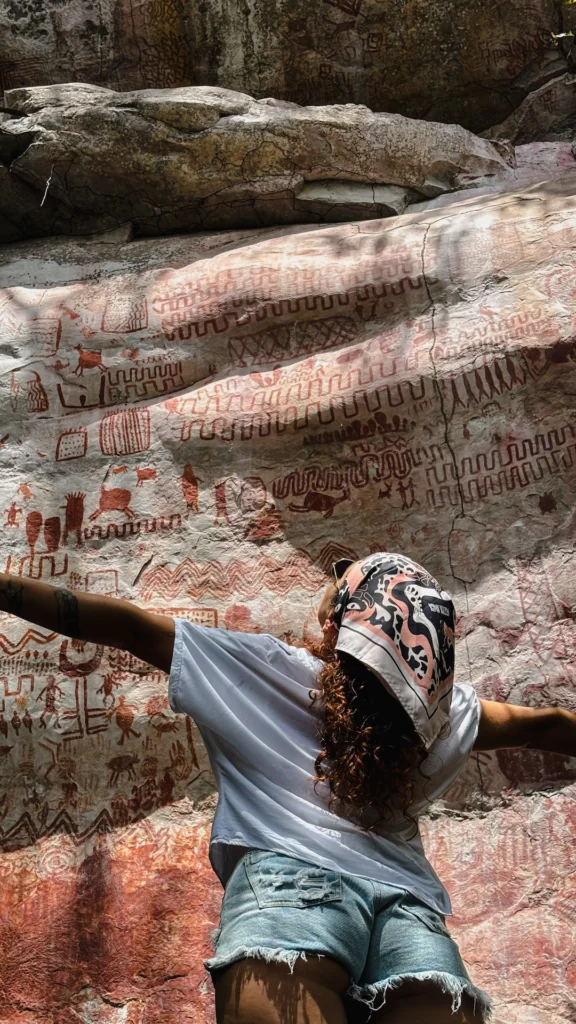 Traveler in front of ancient rupestrian rock art at Cerro Azul, San José del Guaviare, Colombia