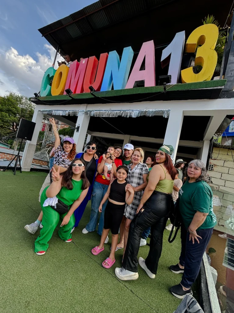 Travel group posing at Comuna 13 sign in Medellín, Colombia